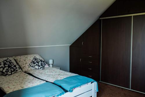a bedroom with a bed and a wooden cabinet at Apartament na Gryfa 8 in Stężyca