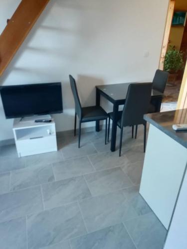 a living room with a table and chairs and a television at Deni09 in Pomer