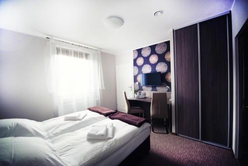a hotel room with a bed and a desk at Makara in Katowice