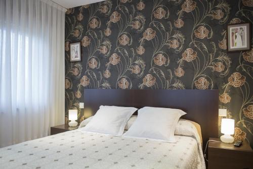 a bedroom with a large bed with a floral wallpaper at Quintana 23 in Suances