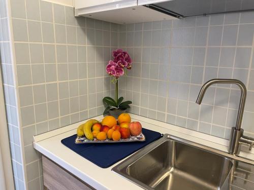 ジャルディーニ・ナクソスにあるNaxos Sicilian Luxury Apartmentの洗面台の横のカウンターの果物皿