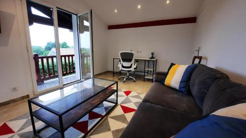 uma sala de estar com um sofá e uma mesa de vidro em Bed & Breakfast L'Etape Basque em Bidart