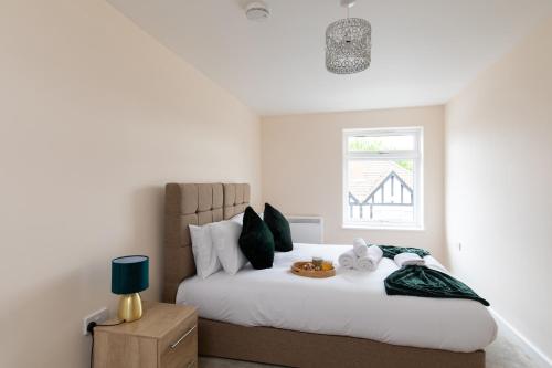 a bedroom with a large white bed with a window at homely - North London Apartments Wembley in Harrow on the Hill