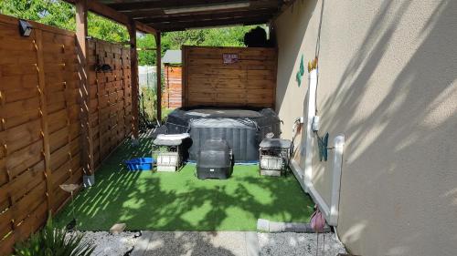an outdoor patio with a bed in a backyard at L'écluse d'Episy-Havre romantique avec spa in Épisy