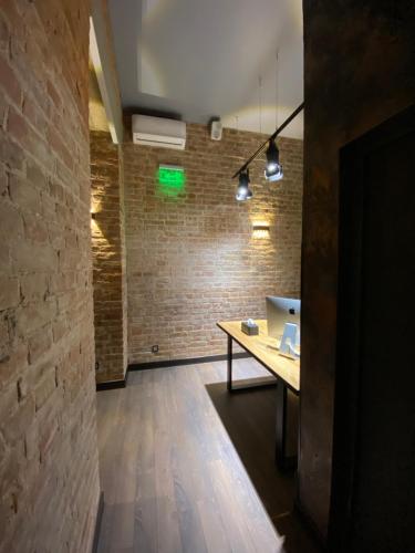 um quarto com uma mesa de madeira e uma parede de tijolos em Lift Rooms em Odessa