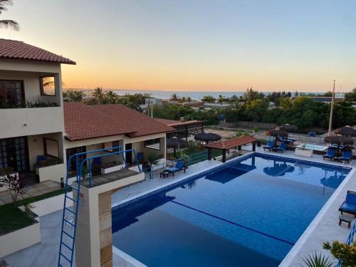 a large swimming pool in front of a house at Hotel Pousada Canoa Quebrada in Canoa Quebrada