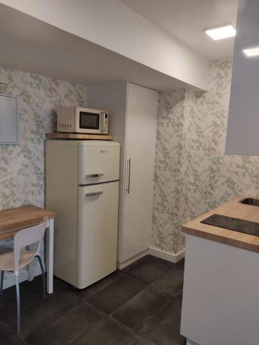 eine Küche mit einer Mikrowelle auf dem Kühlschrank in der Unterkunft Apartamento pequeño, coqueto y céntrico. in Cedeira