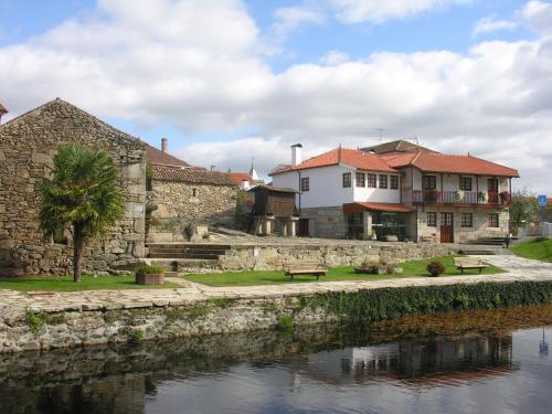 a group of buildings next to a river at Casa de Sao Cristovao in Boticas