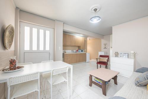 a kitchen and living room with a white table and chairs at Castle's nest 2 in Kástro Tornéze