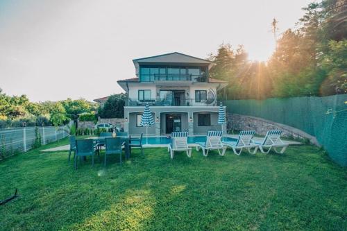 a house with a table and chairs in the yard at FULL MÜSTAKİL GÖL MANZARALI HAVUZLU VİLLA- BTK01 in Sapanca