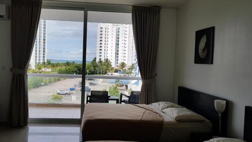 1 dormitorio con cama y ventana grande en Playa Blanca Towncenter Suite - NO incluye comidas, en Playa Blanca