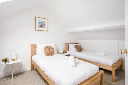 two beds in a room with white walls at Cosy period cottage 2min walk to the beach in Portrush