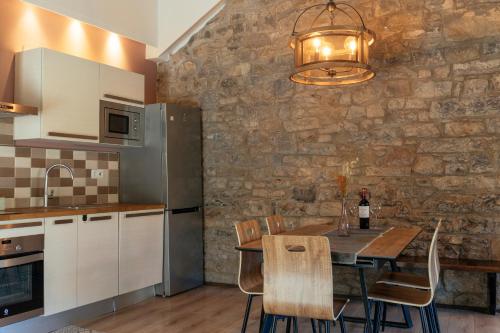 a kitchen with a dining table and a stone wall at La Borda de Chelis in Broto