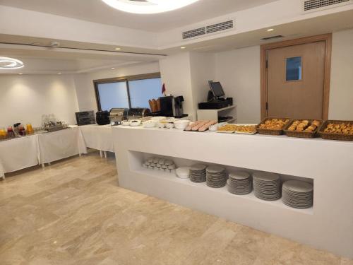 a bakery with a counter with plates and pastries at Fajr Hotel in Oujda