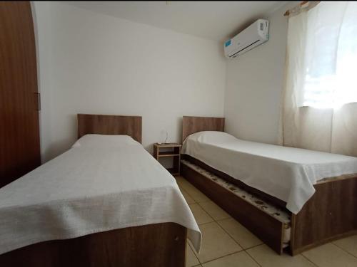 twee eenpersoonsbedden in een kamer met een raam bij Apartamentos Santa Rosa PB 1 in Cordoba