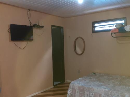 Zimmer mit einem Bett, einem Spiegel und einem Fenster in der Unterkunft Casa Vênus in São Pedro da Serra
