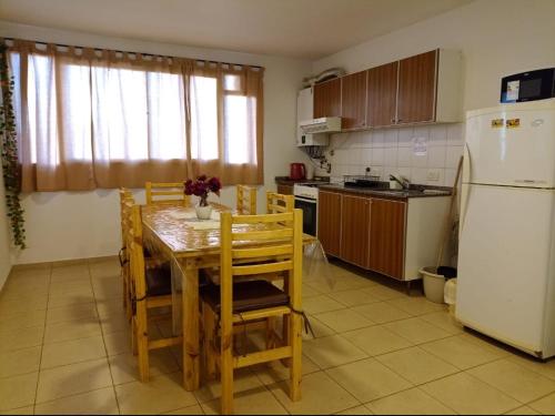 een keuken met een tafel, stoelen en een koelkast bij Apartamentos Santa Rosa PB3 in Cordoba
