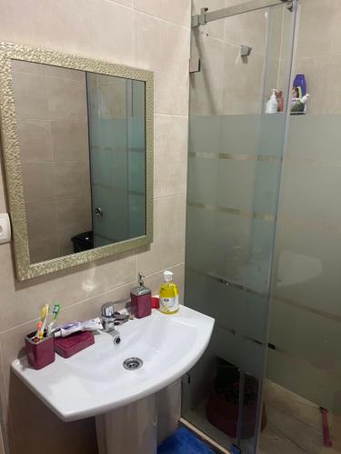 a bathroom with a sink and a shower at Appartement pied dans l eau à Residence Beralmar in Asilah
