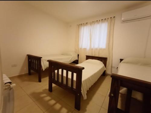 a small bedroom with two beds and a window at Apartamentos Santa Rosa PB3 in Cordoba