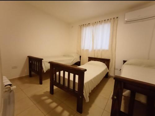 een kleine slaapkamer met twee bedden en een raam bij Apartamentos Santa Rosa PB3 in Cordoba