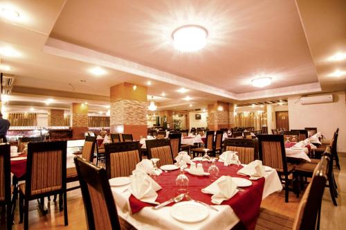 a dining room with tables and chairs in a restaurant at Century Park Residence in Dhaka