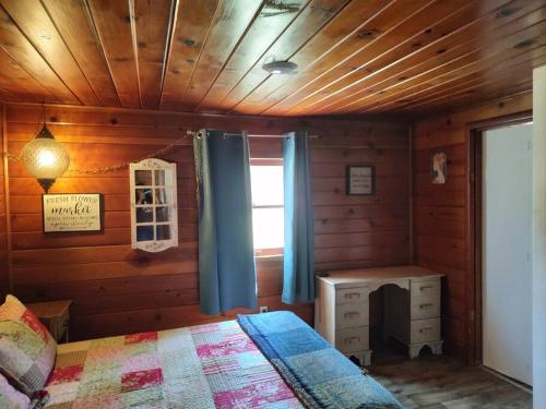 a bedroom with a bed and a desk and a window at O'Brien's Oasis in Miramonte