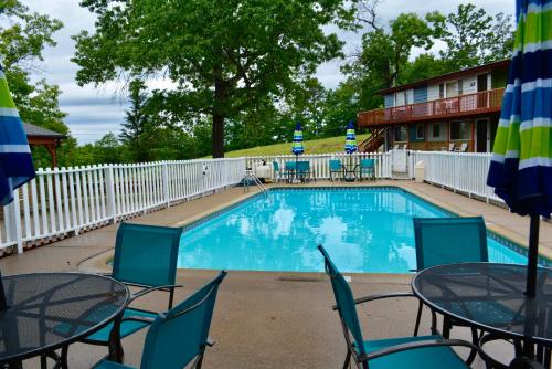 a swimming pool with tables and chairs in front of a hotel at Driftwood Resort Bull Shoals in Bull Shoals