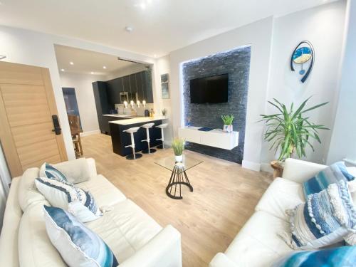 a living room with two white couches and a tv at Cloud9 Guest House - by Coastline Retreats - FREE PARKING INCLUDED - 2 Bedroom self contained garden flat - Luxury 2 Person Bath, Netflix, Superfast Wifi in Bournemouth