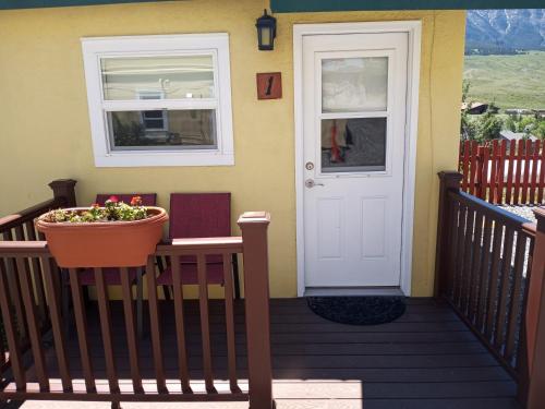 a porch with a white door and a flower pot at Yellowstone Riverside Cottages in Gardiner
