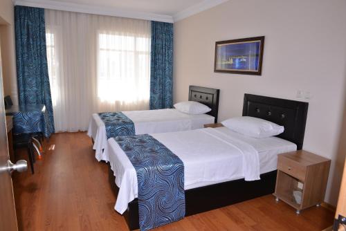 a hotel room with two beds and a window at Emsa Otel Maltepedeki Eviniz in Istanbul