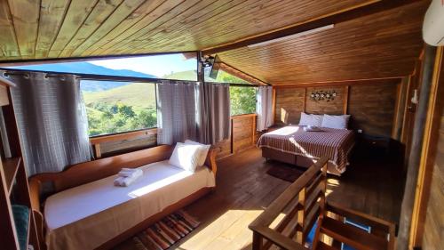 a bedroom with a bed and a bed and a window at Pousada Sitio Barreirinha in Engenheiro Passos