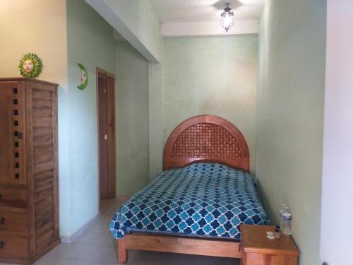 a bedroom with a bed with a wooden head board at Hotel Villas Monteli Suites Cuernavaca in Cuernavaca