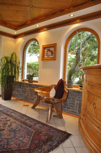 a living room with a chair and two windows at Active Apart Central in Ried im Oberinntal