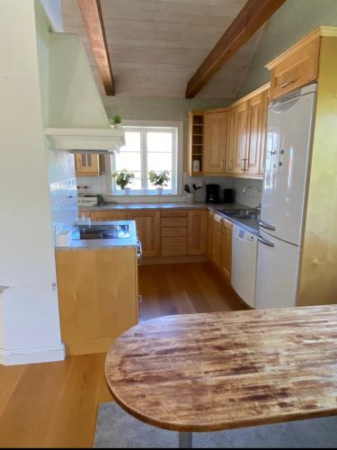 a kitchen with wooden cabinets and a wooden table at Villa i Norrtälje in Norrtälje