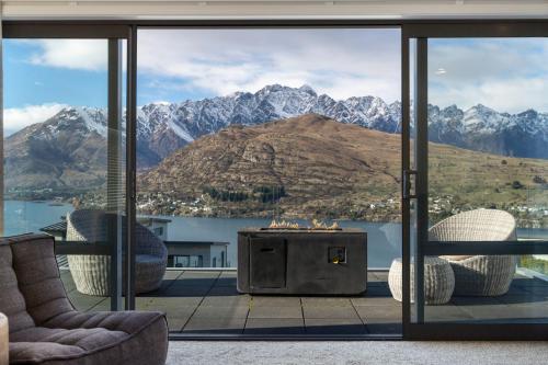 a living room with a fireplace and a view of mountains at Highview Haven by Relaxaway Holiday Homes in Queenstown