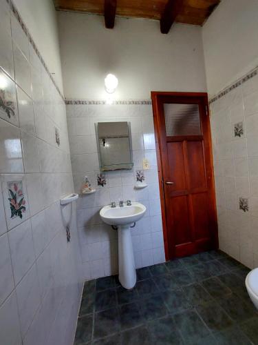 a bathroom with a sink and a red door at Hostal killari in Cafayate