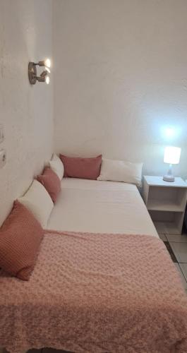 una camera da letto con un grande letto bianco con cuscini rossi di Studio Kreyol Lecusson a Saint-François