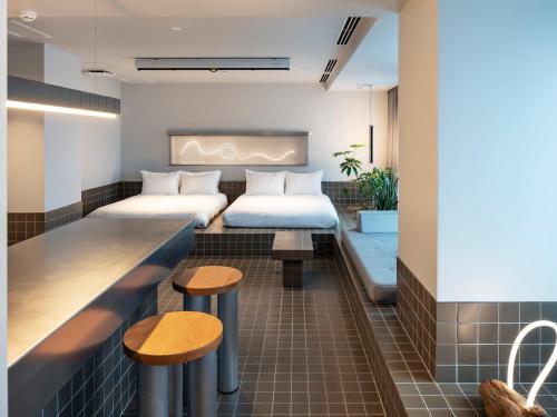 a hotel room with two beds and a bar at all day place shibuya in Tokyo