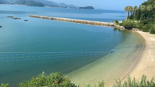 a view of a beach next to a body of water at Rakusansui Villa in Itoshima
