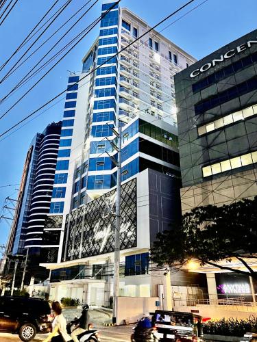 a woman riding a bike in front of a tall building at Inspiria in Davao City