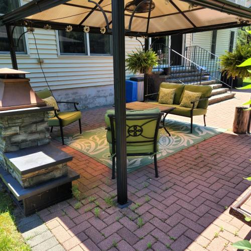a patio with a table and chairs under an umbrella at Comfortable, spacious, 1bdrm basement apartment, sleeps 4 in Milton