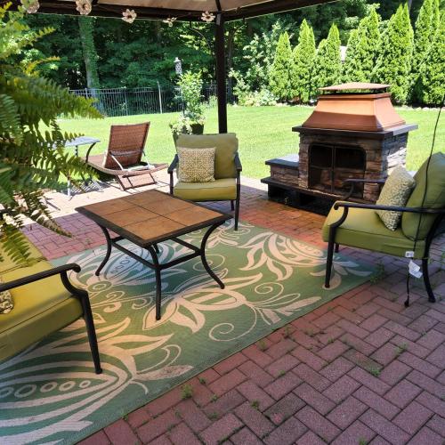a patio with chairs and a table and a fireplace at Comfortable, spacious, 1bdrm basement apartment, sleeps 4 in Milton
