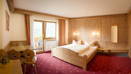 a bedroom with a large bed in a room at Alpenpension Pfurtscheller in Neustift im Stubaital