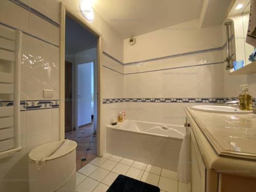 une salle de bain avec une baignoire, des toilettes et un lavabo dans l'établissement Location 3 chambres avec piscine, tennis et garage - Clim, Terrasse et Proche Plage - FR-1-100-279, à Cavalaire-sur-Mer