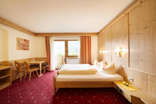 a hotel room with a bed and a table at Alpenpension Pfurtscheller in Neustift im Stubaital