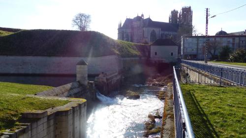 a small canal with a building in the background at Hotel De L'Europe in Toul