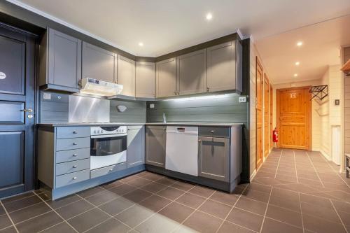 a kitchen with blue cabinets and white appliances at Hemsedal-Toppen av Skarsnuten in Hemsedal