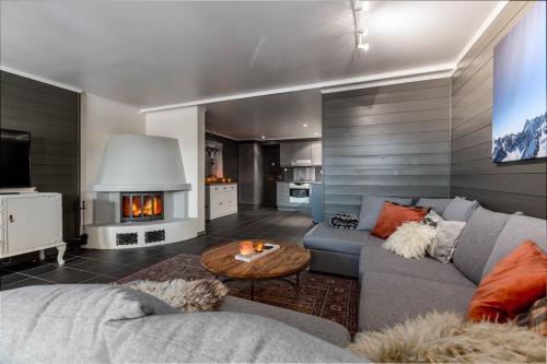a living room with a couch and a fireplace at Hemsedal-Toppen av Skarsnuten in Hemsedal