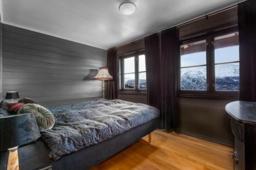 a bedroom with a bed and windows with mountains at Hemsedal-Toppen av Skarsnuten in Hemsedal