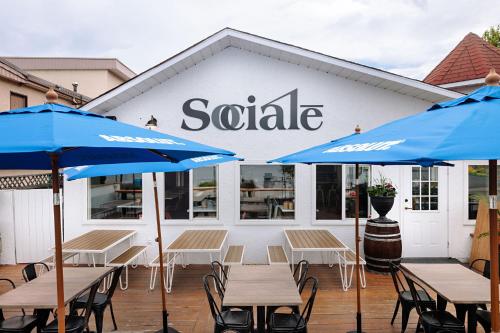 a patio with tables and umbrellas in front of a saale building at Kettle Valley Beach Resort in Penticton